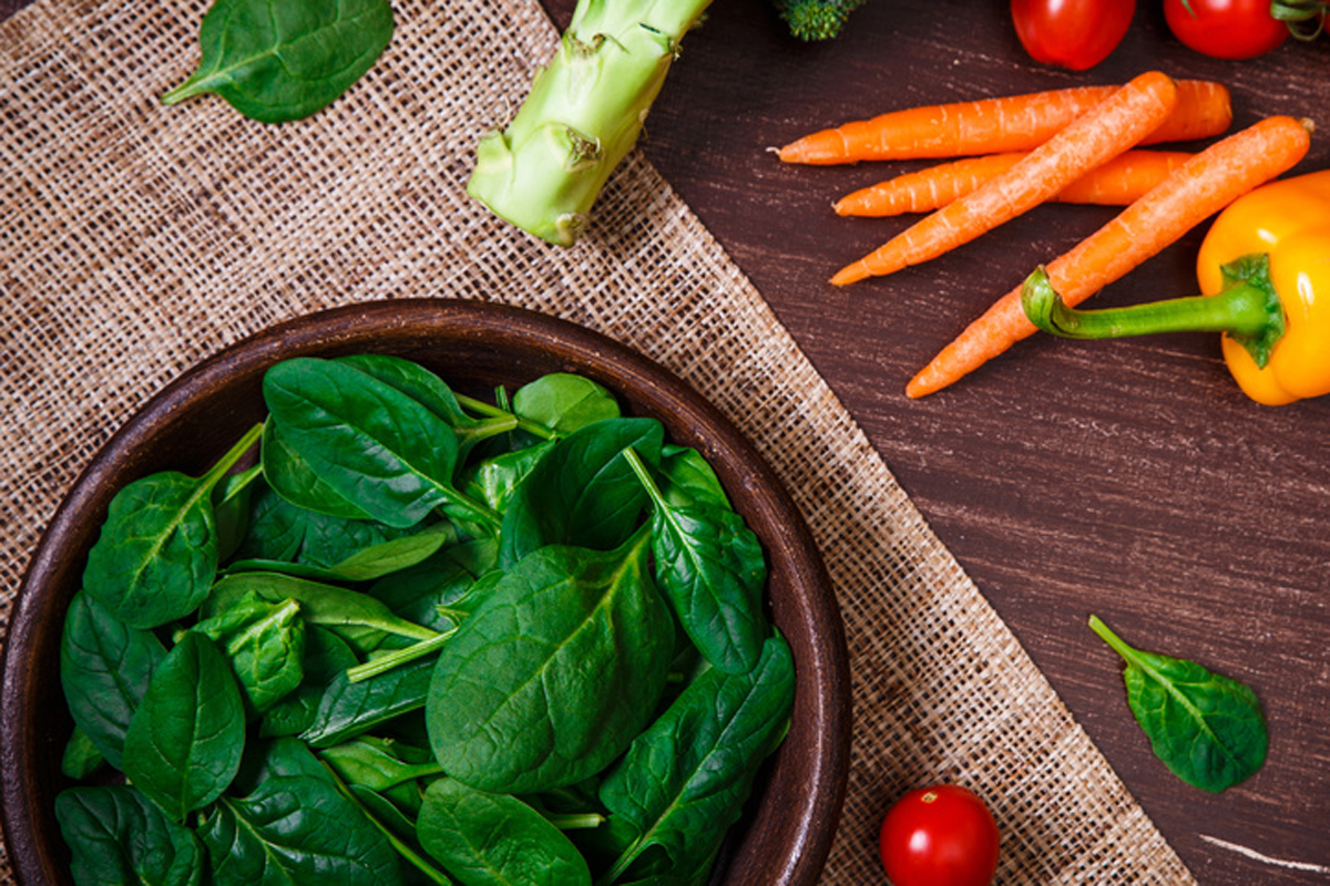 Spinach leaves in bowl. Raw fresh vegetable.