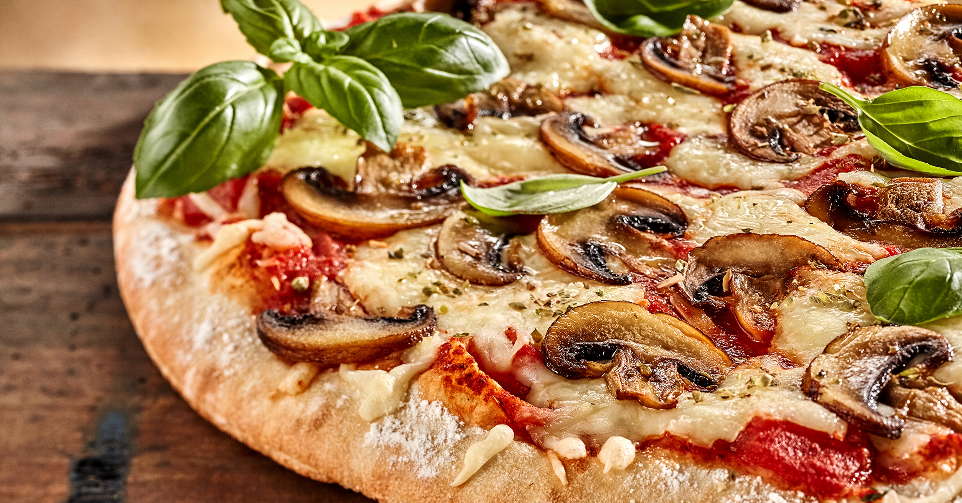 Fresh basil on top of cheese and mushroom pizza Fresh basil on top of cheese and mushroom pizza