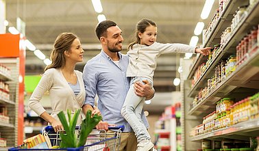family with food in shopping cart at grocery store