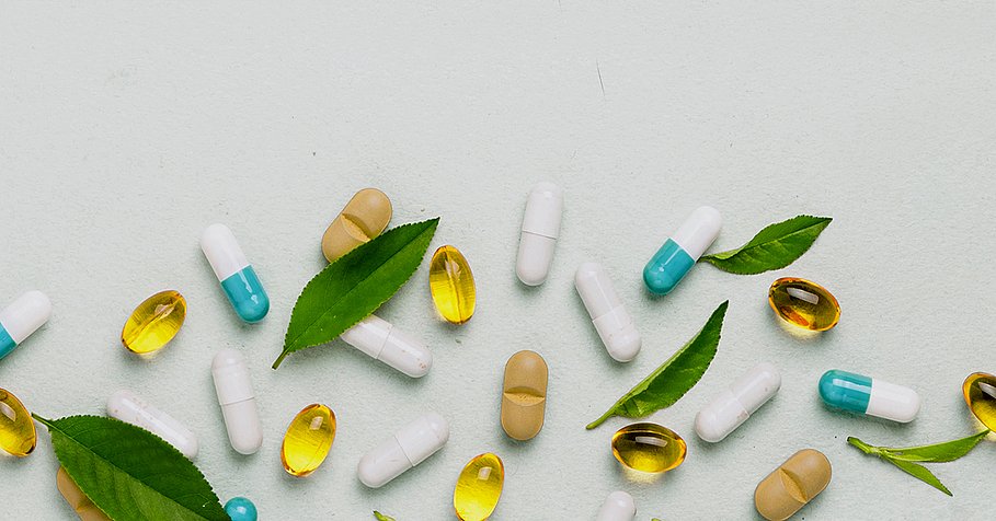 Different tablets, capsules, pills are scattered from the jar on a light background The concept of health Minimalism