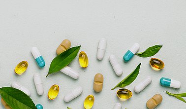 Different tablets, capsules, pills are scattered from the jar on a light background The concept of health Minimalism