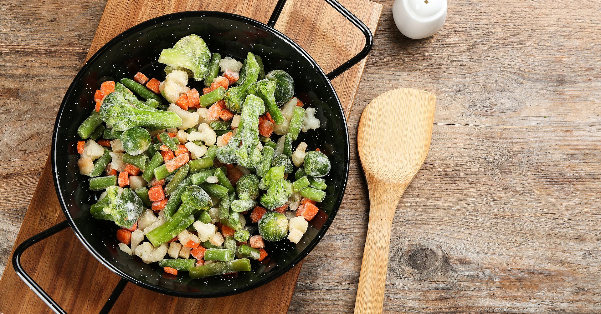 Tasty frozen vegetable mix on wooden table, flat lay