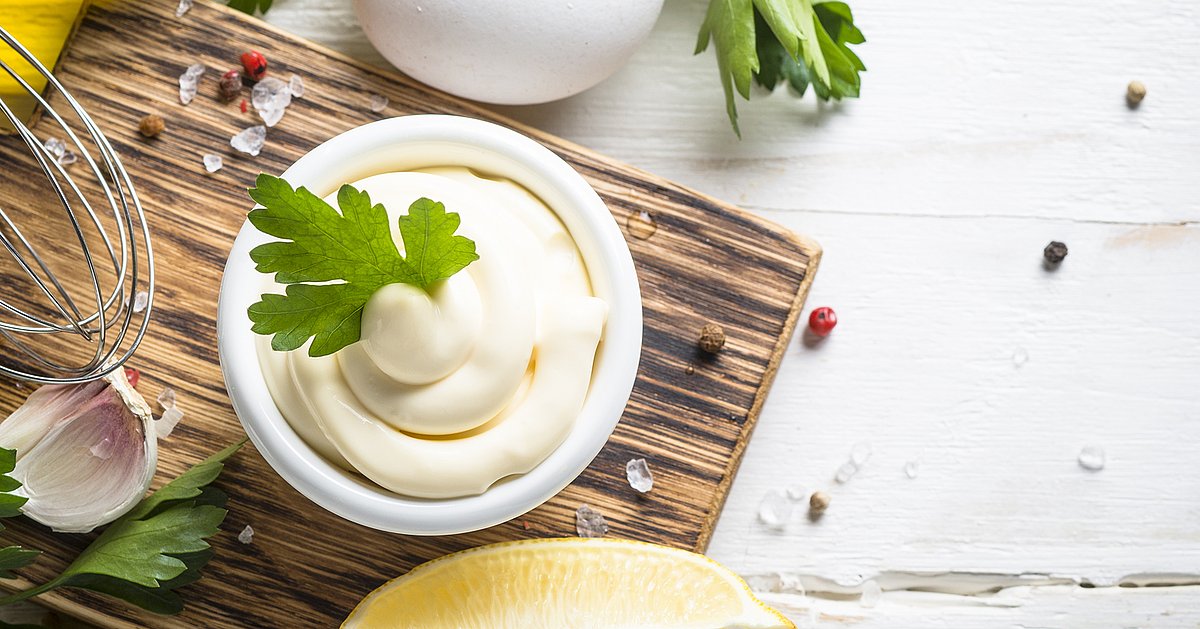 Mayonnaise sauce on white stone table.