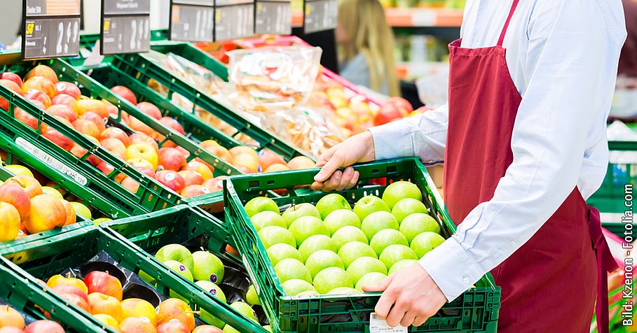 Hypermarket clerk filling up storage racks