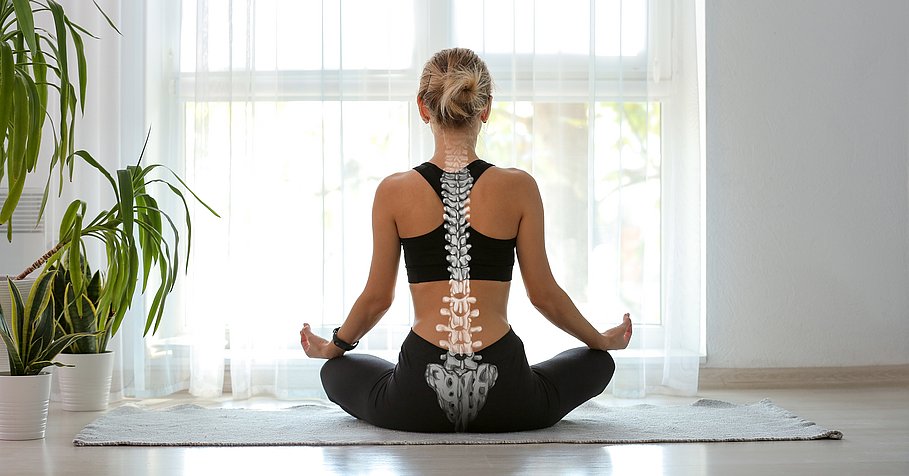 Frau von hinten im Schneidersitz auf Yoga-Matte