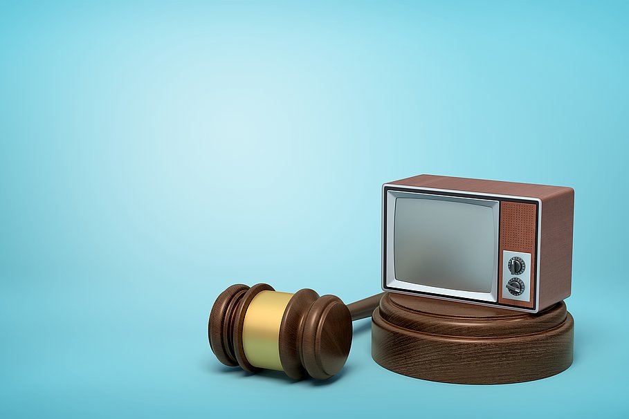 3D-Rendering von Vintage-TV-Gerät auf runden Holzblock und braunen Holzhammer auf blauem Hintergrund