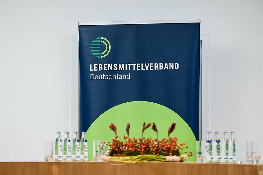 Podium mit Blumenschmuck und Banner im Hintergrund