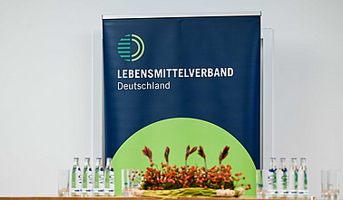 Podium mit Blumenschmuck und Banner im Hintergrund