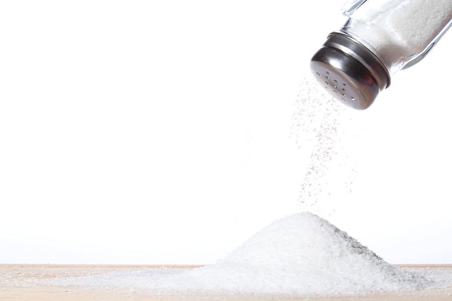 Ein Salzstreuer streut Salz auf eine Oberfläche