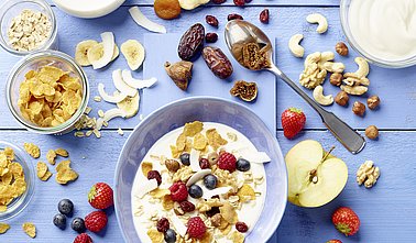 Eine Schlüssel mit Müsli, Naturjoghurt und verschiedenem Obst