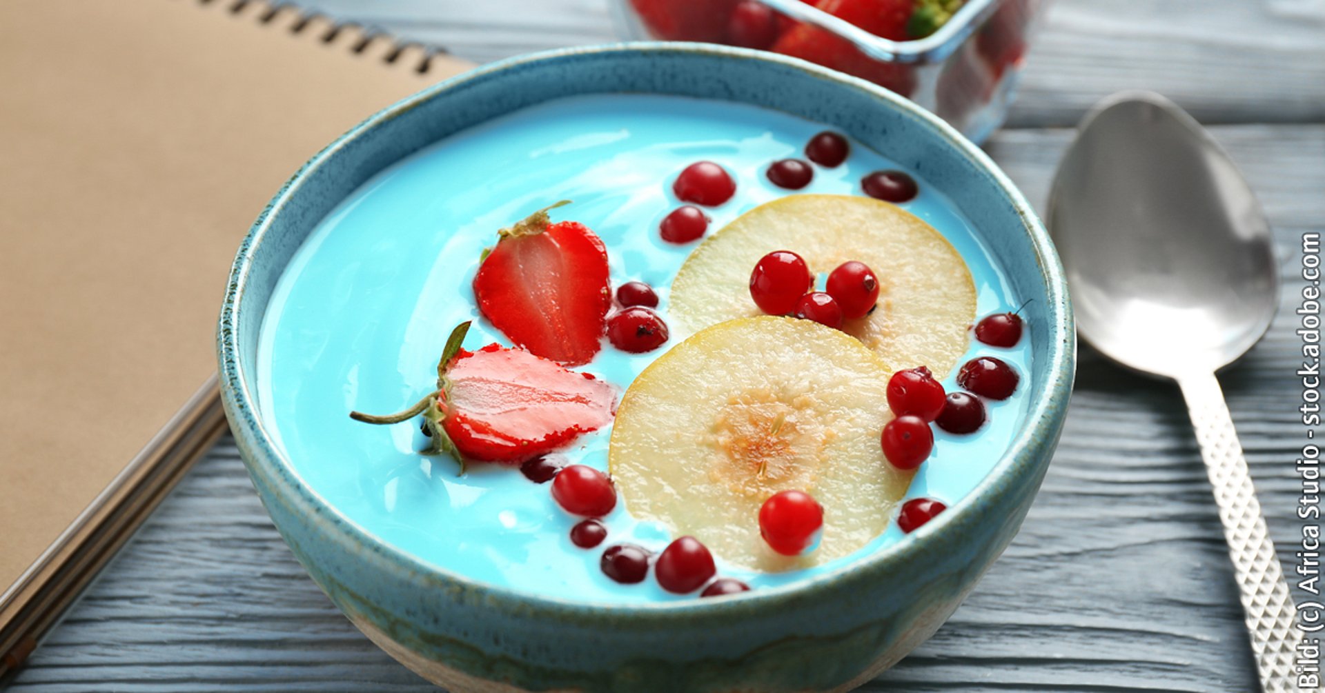 Bowl with blue spirulina smoothie on table. Healthy vegan food concept