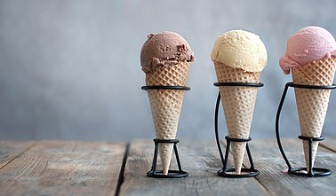 drei Speiseeis in der Waffel mit Schokolade-, Vanille-, und Erdbeergeschmack 