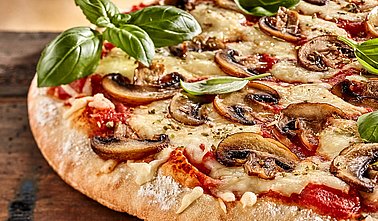 Pizza mit Champignons und Basilikum
