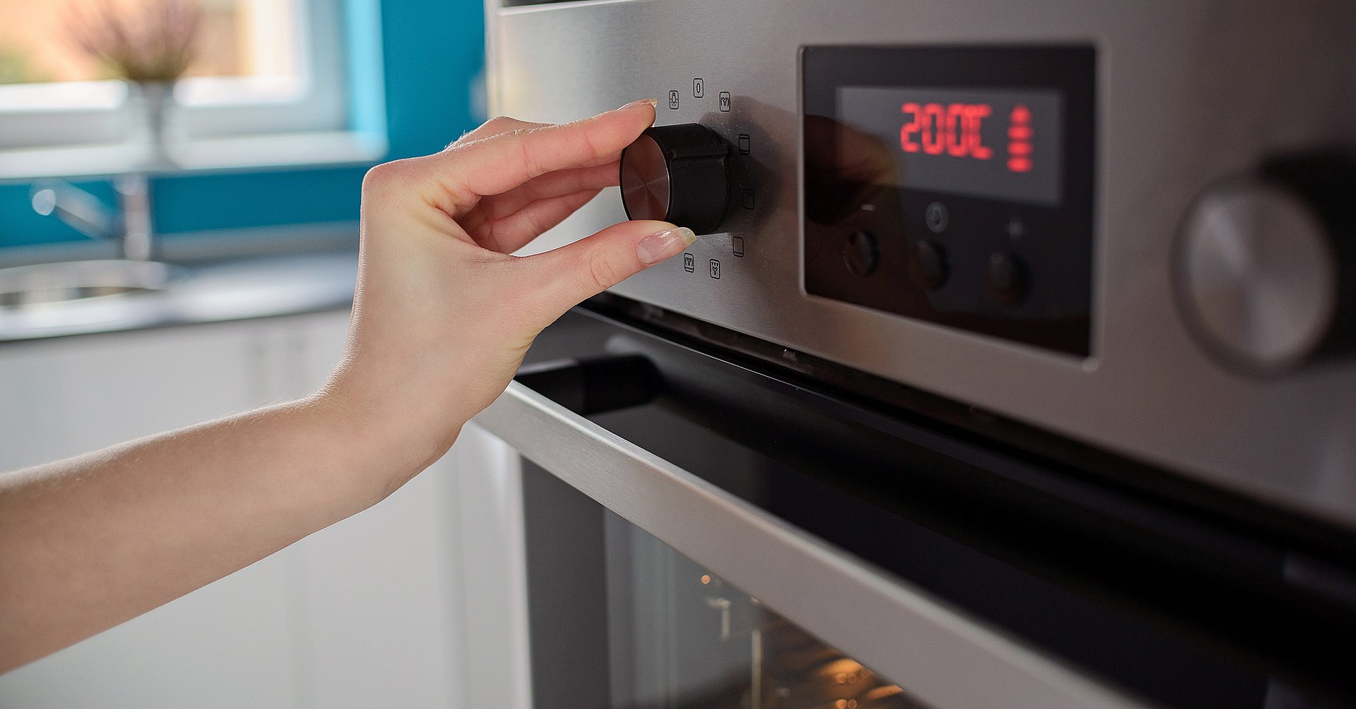 Woman regulates the temperature of the oven Woman regulates the temperature of the oven