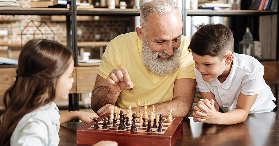 Grandfather showing his grandchildren how to play chess