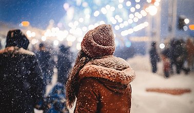 Unrecognizable Woman Walking Through Christmas Fair In Night City