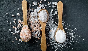 Different types of salt. Top view on three wooden spoons